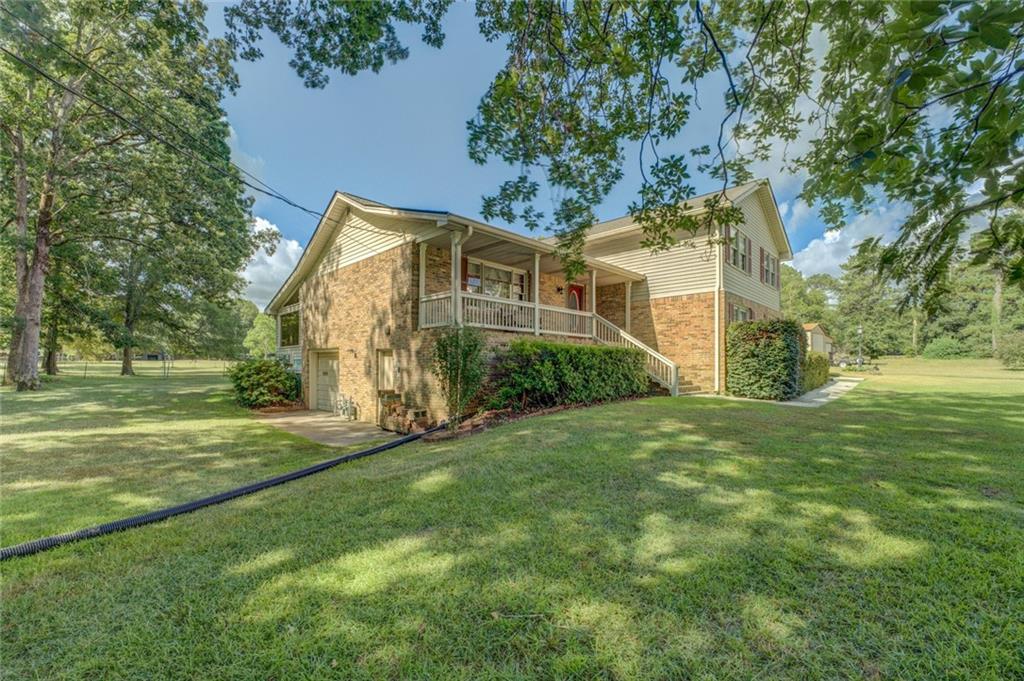740 Smyrna Road Southwest Conyers, GA 30094 - Photo 40 of 50 a view of a big house with a big yard and large trees