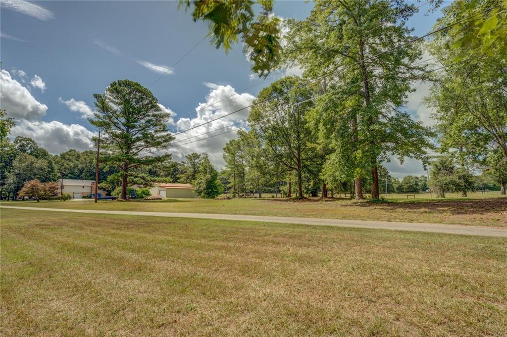 740 Smyrna Road Southwest Conyers, GA 30094 - Photo 48 of 50 a front view of a house with a big yard and a large tree