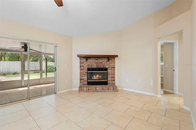 a view of empty room with a fireplace and fan