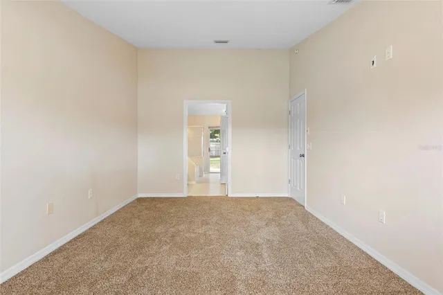 a bedroom with a large bed and a potted plant