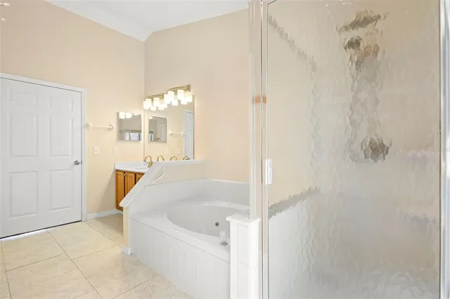 an empty room with a chandelier fan and windows