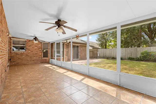 a view of a white house with a big yard plants and large trees