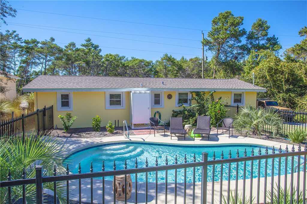 a view of a house with backyard and sitting area
