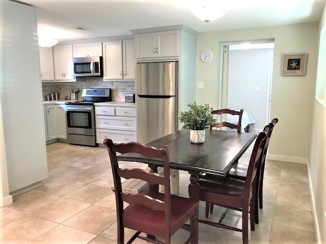 244 Hilltop Drive Santa Rosa Beach, FL 32459 - Photo 6 of 20 a kitchen with a dining table and refrigerator