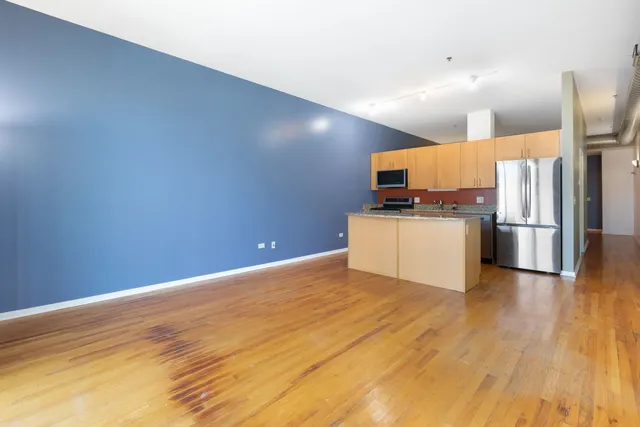 a kitchen with granite countertop a refrigerator and a stove top oven