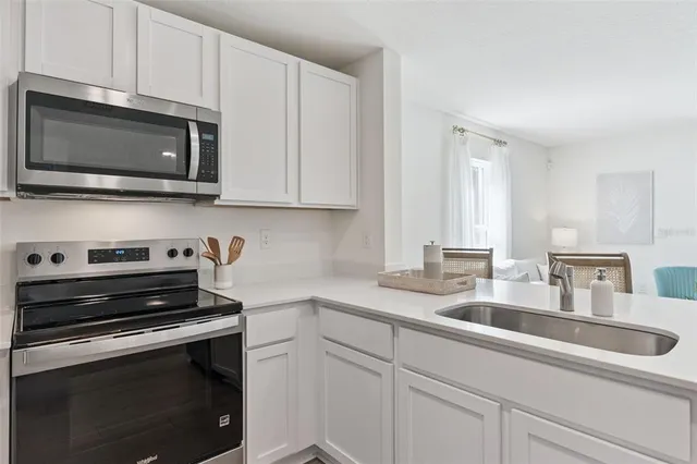 a kitchen with stainless steel appliances a stove microwave and sink