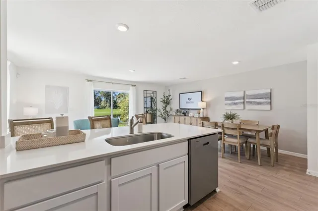 a kitchen with sink and view of living room