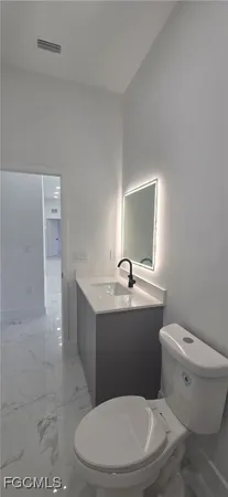 a white toilet sitting next to a bathroom sink