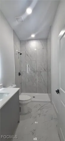 a bathroom with a shower a toilet and sink