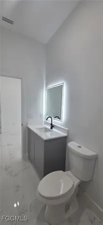 a bathroom with a toilet a sink and mirror