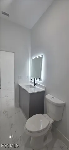 a bathroom with a toilet a sink and mirror