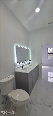 a bathroom with a toilet a sink and mirror