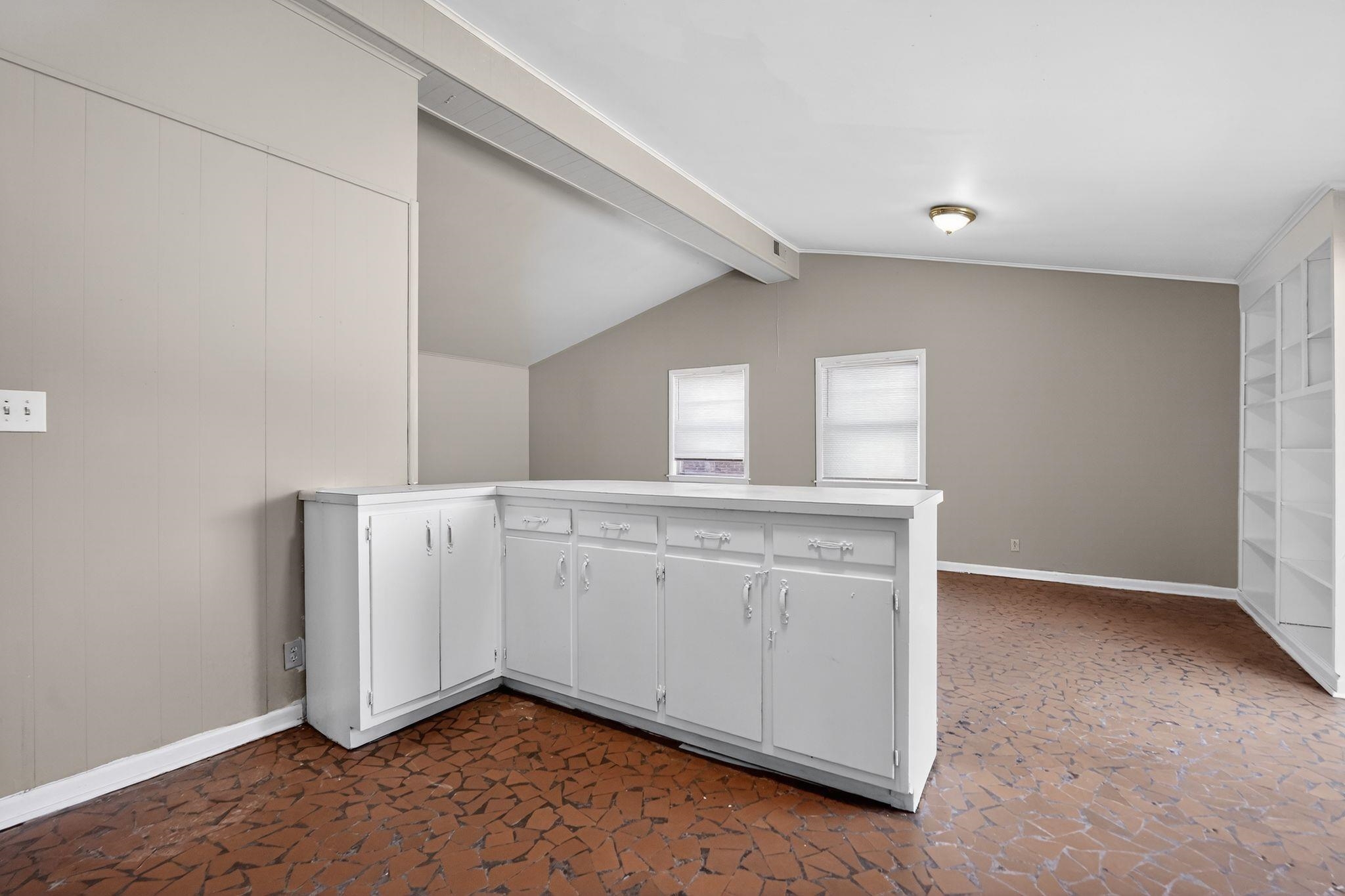 3445 Powers Road Memphis, TN 38128 - Photo 24 of 35 Room featuring a built-in white cabinet bar, two windows with blinds, a vaulted ceiling with exposed beam, and built-in white shelving