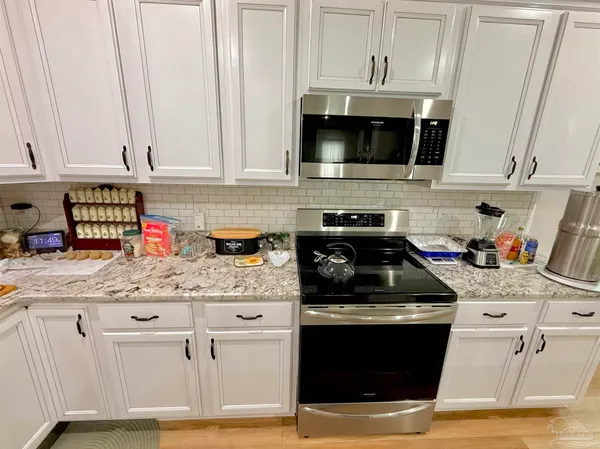 a kitchen with stainless steel appliances granite countertop a stove sink and cabinets