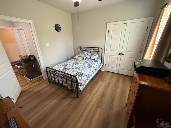 a bedroom with a bed and wooden floor