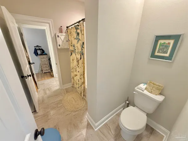 a white toilet sitting next to a bathroom sink and a shower