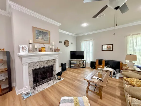 a living room with furniture a fireplace and a flat screen tv