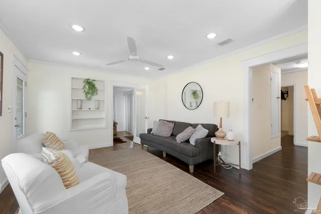 a living room with furniture and a wooden floor