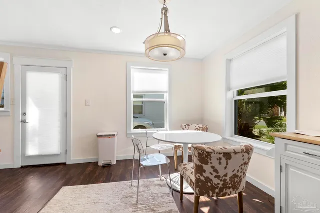 a dining room with wooden floor a chandelier a wooden table and chairs