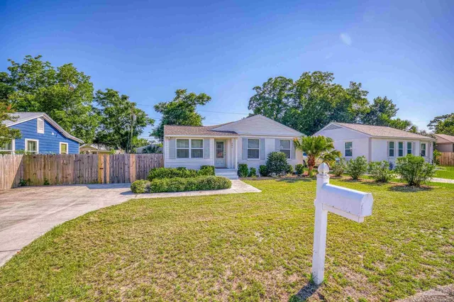 a front view of a house with yard and green space