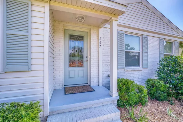 a view of front door of a house with potted plants