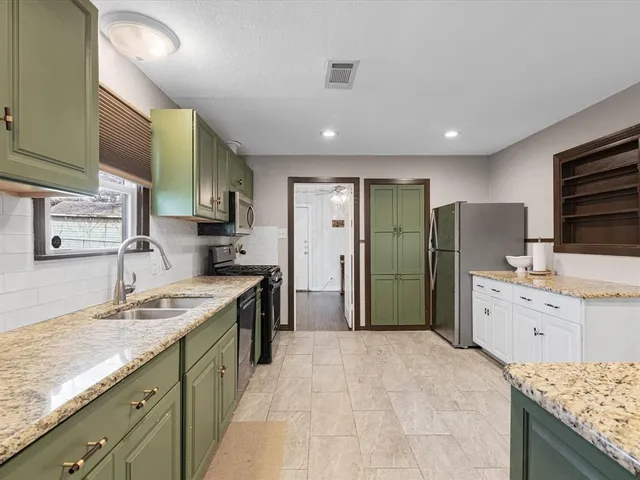 a large kitchen with stainless steel appliances granite countertop a sink stove and refrigerator
