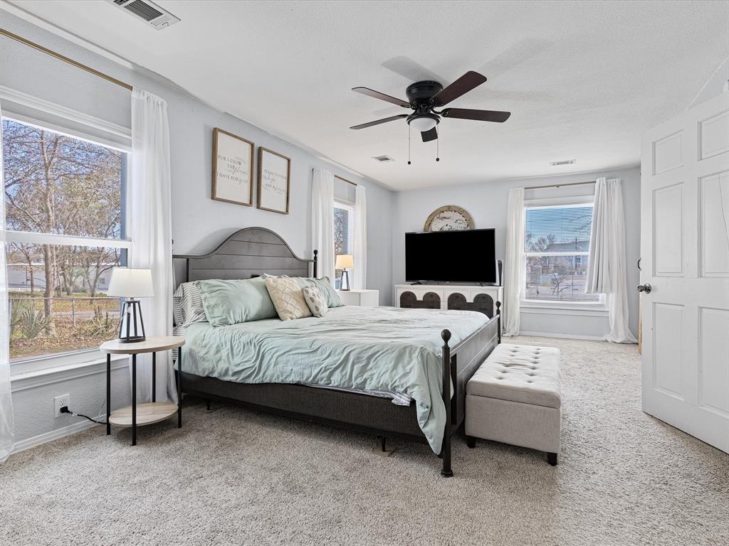 1308 Myrtle Street Denton, TX 76201 - Photo 18 of 35 a spacious bedroom with a bed and a flat screen tv