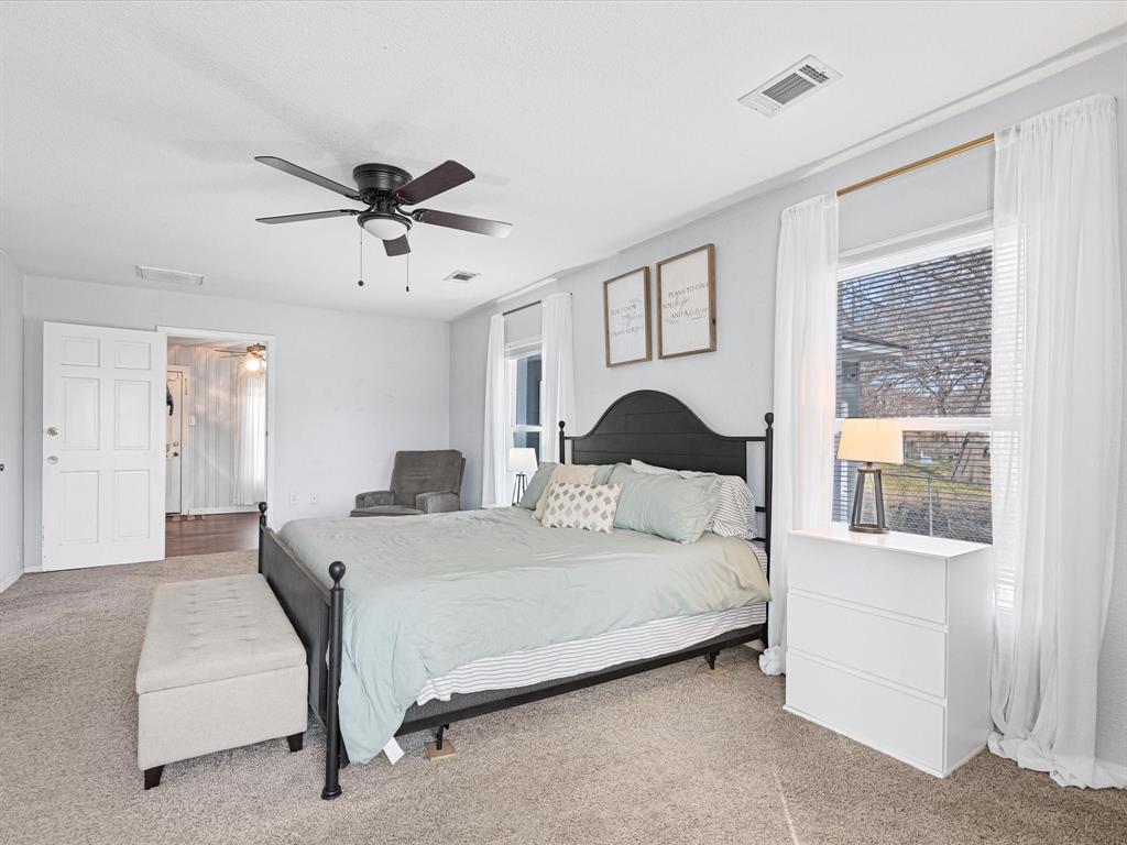 1308 Myrtle Street Denton, TX 76201 - Photo 19 of 35 a bedroom with a large bed and a chandelier fan