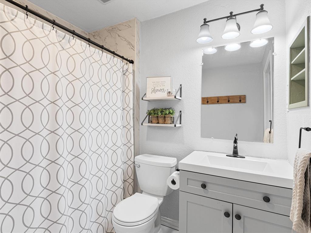 1308 Myrtle Street Denton, TX 76201 - Photo 21 of 35 a bathroom with a sink a toilet and a mirror
