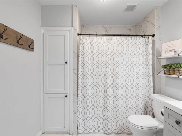 a white toilet sitting next to a shower curtain