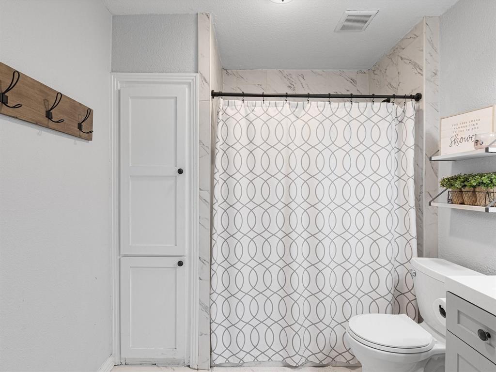 1308 Myrtle Street Denton, TX 76201 - Photo 22 of 35 a white toilet sitting next to a shower curtain