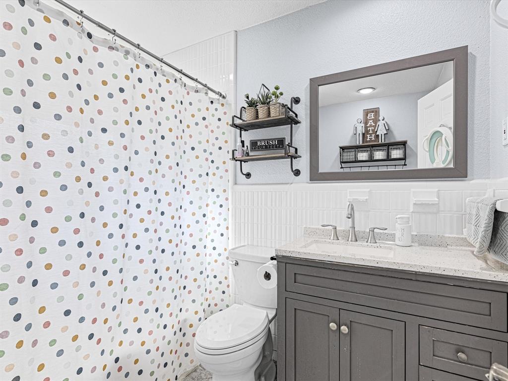 1308 Myrtle Street Denton, TX 76201 - Photo 25 of 35 a bathroom with a sink a toilet and a mirror