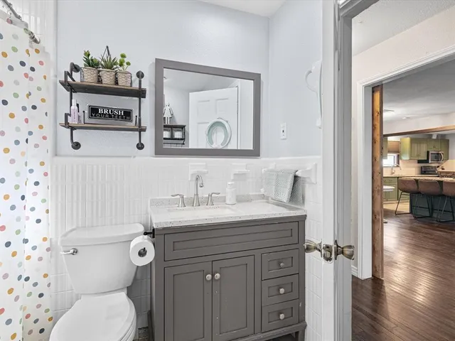 a bathroom with a granite countertop toilet sink and mirror