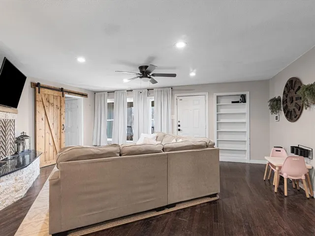a living room with furniture a flat screen tv and a large window