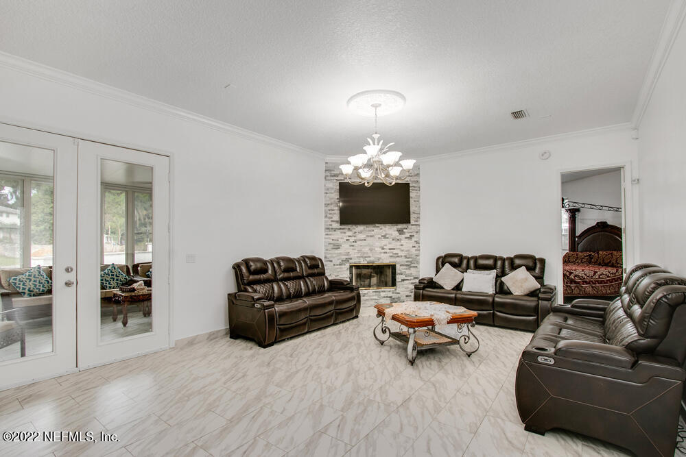 4232 Heath Road Jacksonville, FL 32277 - Photo 4 of 35 a living room with furniture and a chandelier