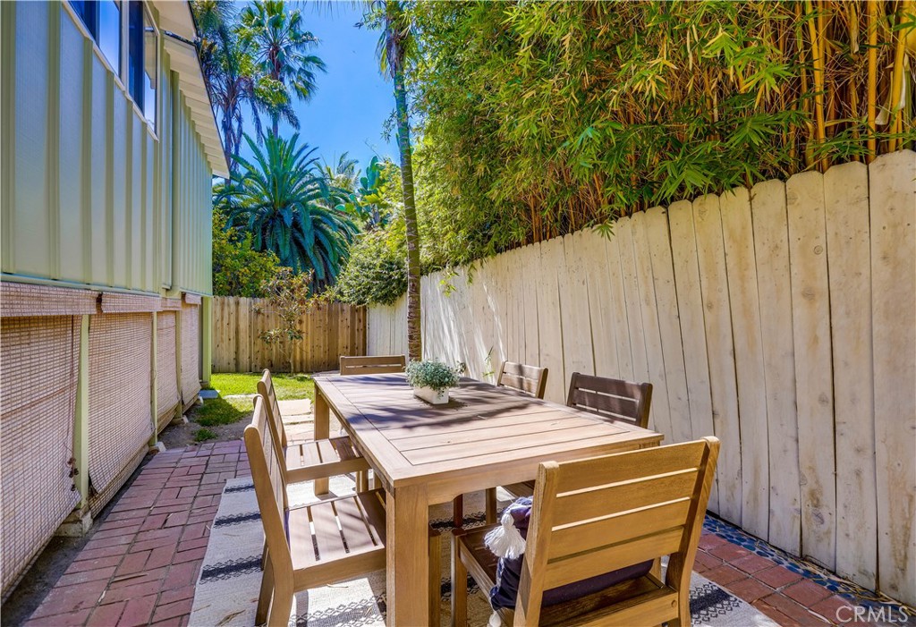 464 Agate Street, Unit A/B Laguna Beach, CA 92651 - Photo 74 of 75 a view of a patio with table and chairs with wooden floor and fence