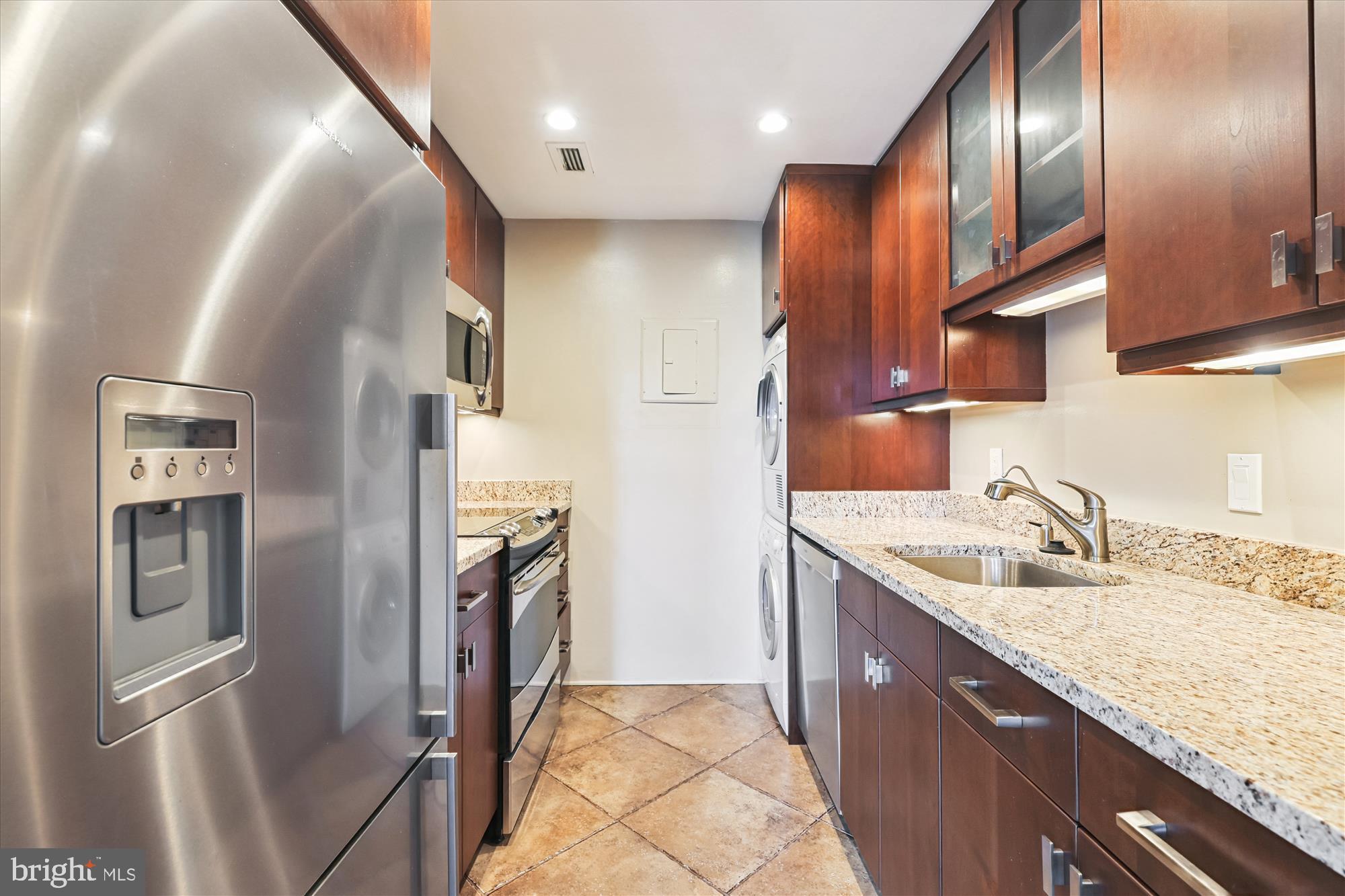 955 26th Street Northwest, Unit 803 Washington, DC 20037 - Photo 14 of 54 a kitchen with stainless steel appliances granite countertop a refrigerator a sink and wooden cabinets