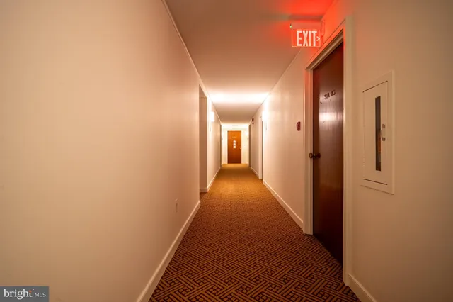 a view of a hallway with wooden floor and closet