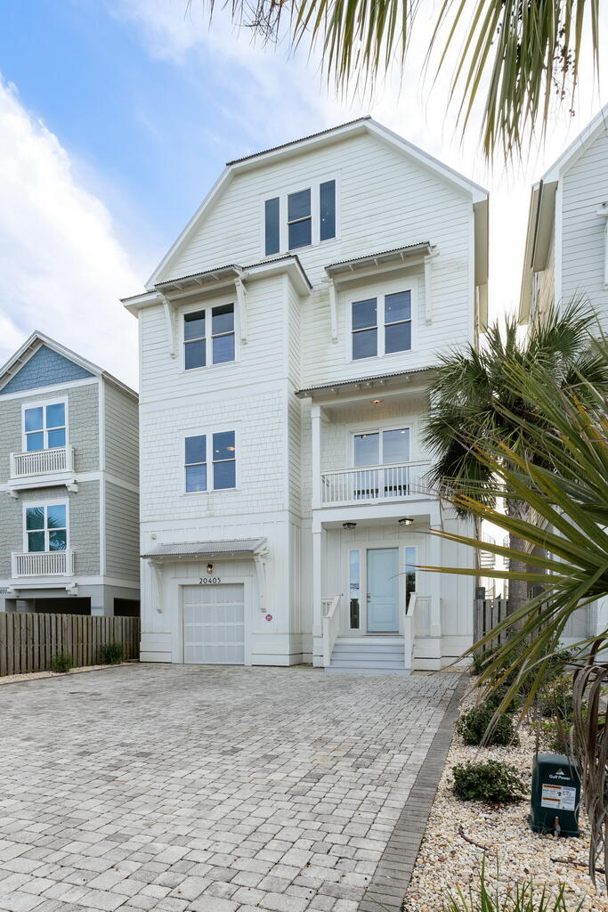 20405 Front Beach Road Panama City Beach, FL 32413 - Photo 34 of 130 a front view of a house with a yard and garage