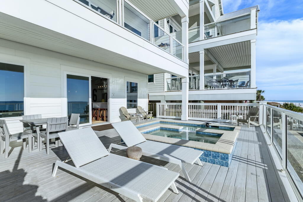 20405 Front Beach Road Panama City Beach, FL 32413 - Photo 51 of 130 a view of a patio with couches table and chairs with wooden floor and fence