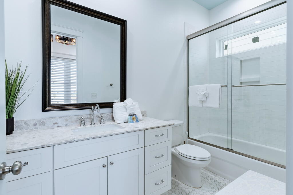20405 Front Beach Road Panama City Beach, FL 32413 - Photo 68 of 130 a bathroom with a granite countertop sink toilet a large mirror a vanity and shower