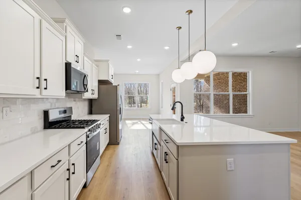 a kitchen with a sink cabinets and wooden floor