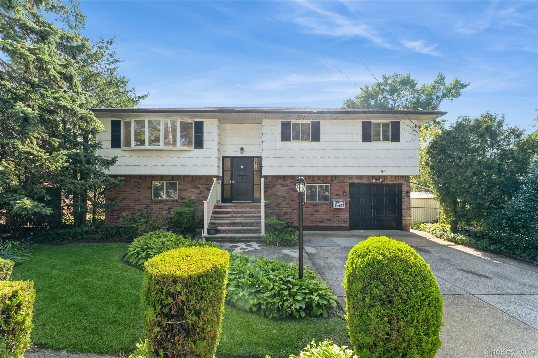 59 Cornwell Avenue Valley Stream, NY 11580 - Photo 1 of 1 a front view of a house with garden