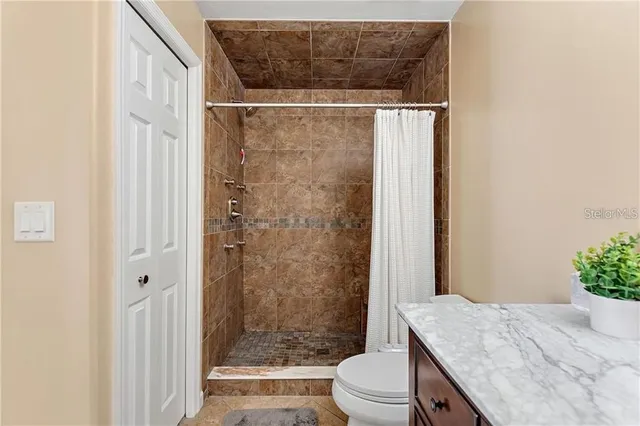 a bathroom with a granite countertop sink toilet and shower