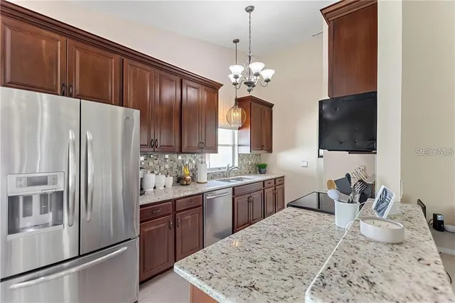 a kitchen with stainless steel appliances granite countertop a refrigerator stove top oven and sink