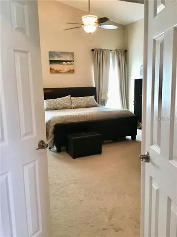 a spacious bedroom with a bed and a chandelier