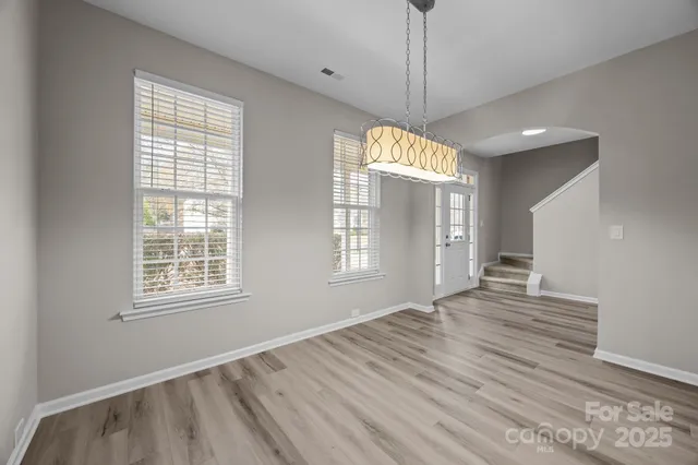 a view of empty room with wooden floor and window