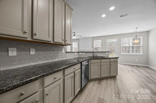 a kitchen with appliances a sink cabinets and a window
