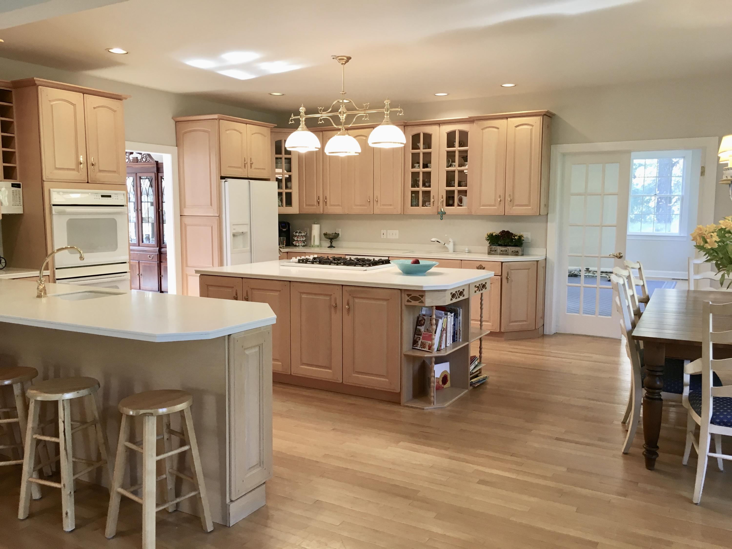 152 Old Studio Road New Canaan, CT 06840 - Photo 6 of 35 a kitchen with a dining table chairs cabinets wooden floor and appliances