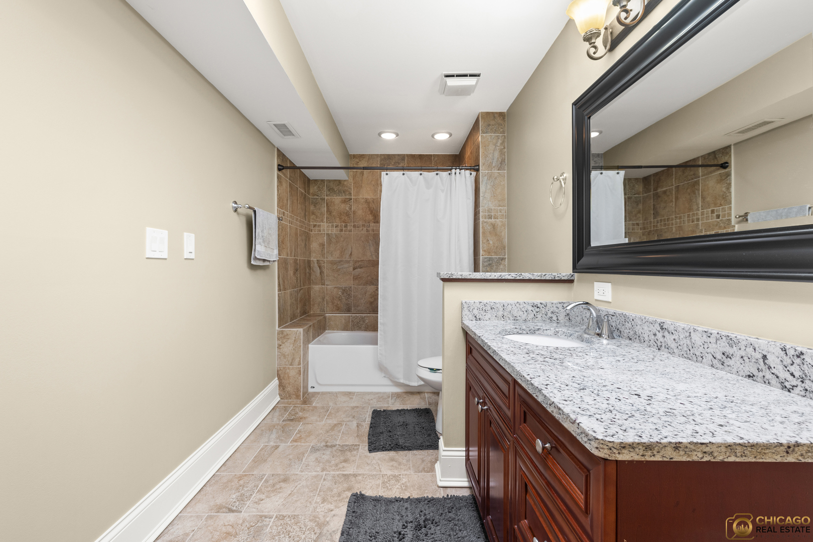 1631 West Partridge Court, Unit 8 Arlington Heights, IL 60004 - Photo 17 of 26 a bathroom with a granite countertop sink a mirror and a bathtub